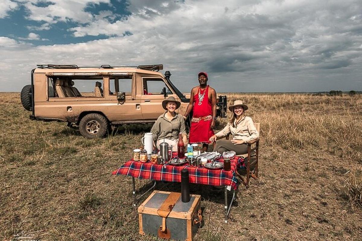 um grupo de pessoas sentadas em uma mesa de piquenique em um campo