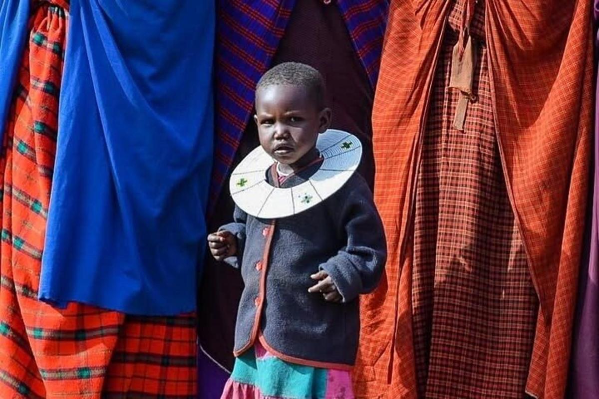 Un niño sostiene un reloj en su camisa.