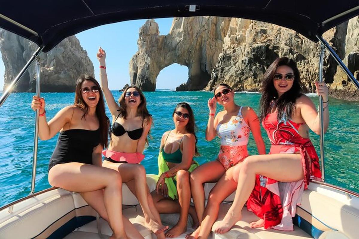 μια ομάδα γυναικών που κάθονται σε μια βάρκα μπροστά σε μια σπηλιά
