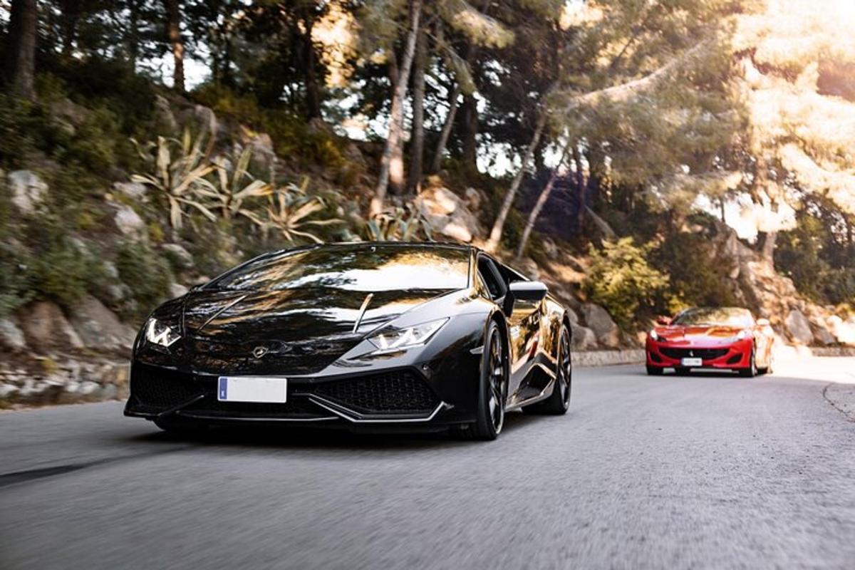sebuah lamborghini hitam dan sebuah kereta merah di jalan raya