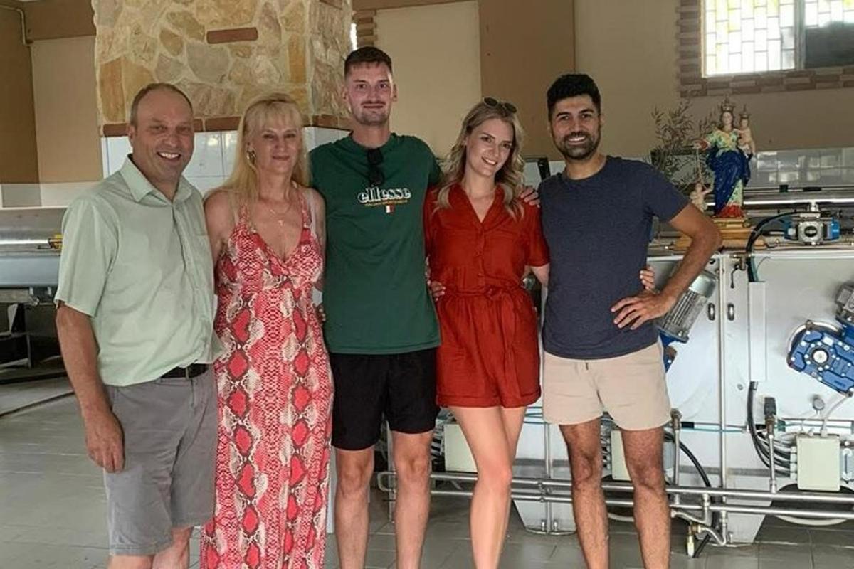 a group of people posing for a picture in a kitchen