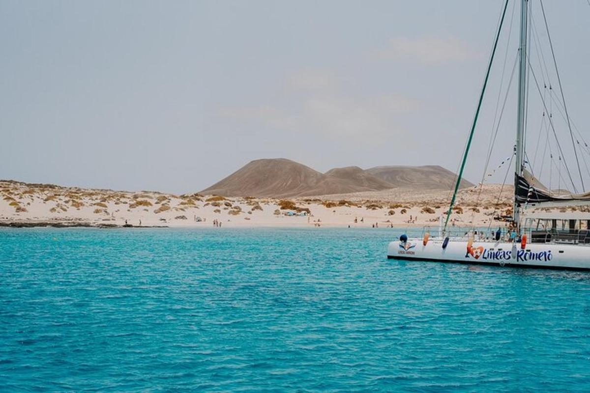a boat in the water with a beach in the background