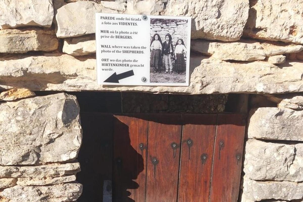 a sign above a wooden door in a stone wall