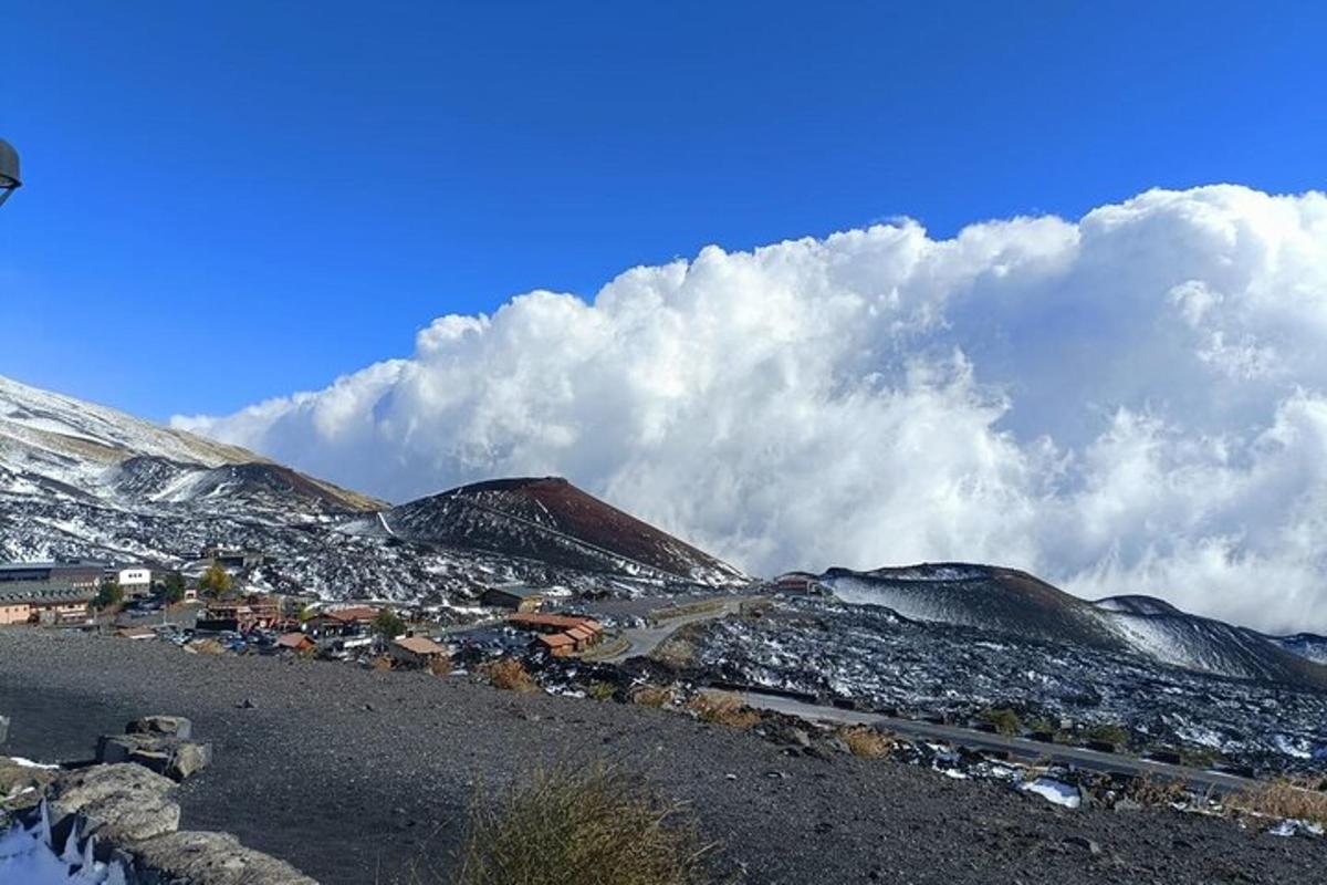 een klein stadje op een besneeuwde berg met wolken in de lucht
