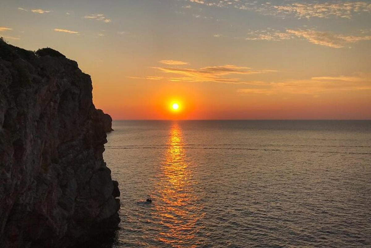 залазак сунца над океаном близу литице