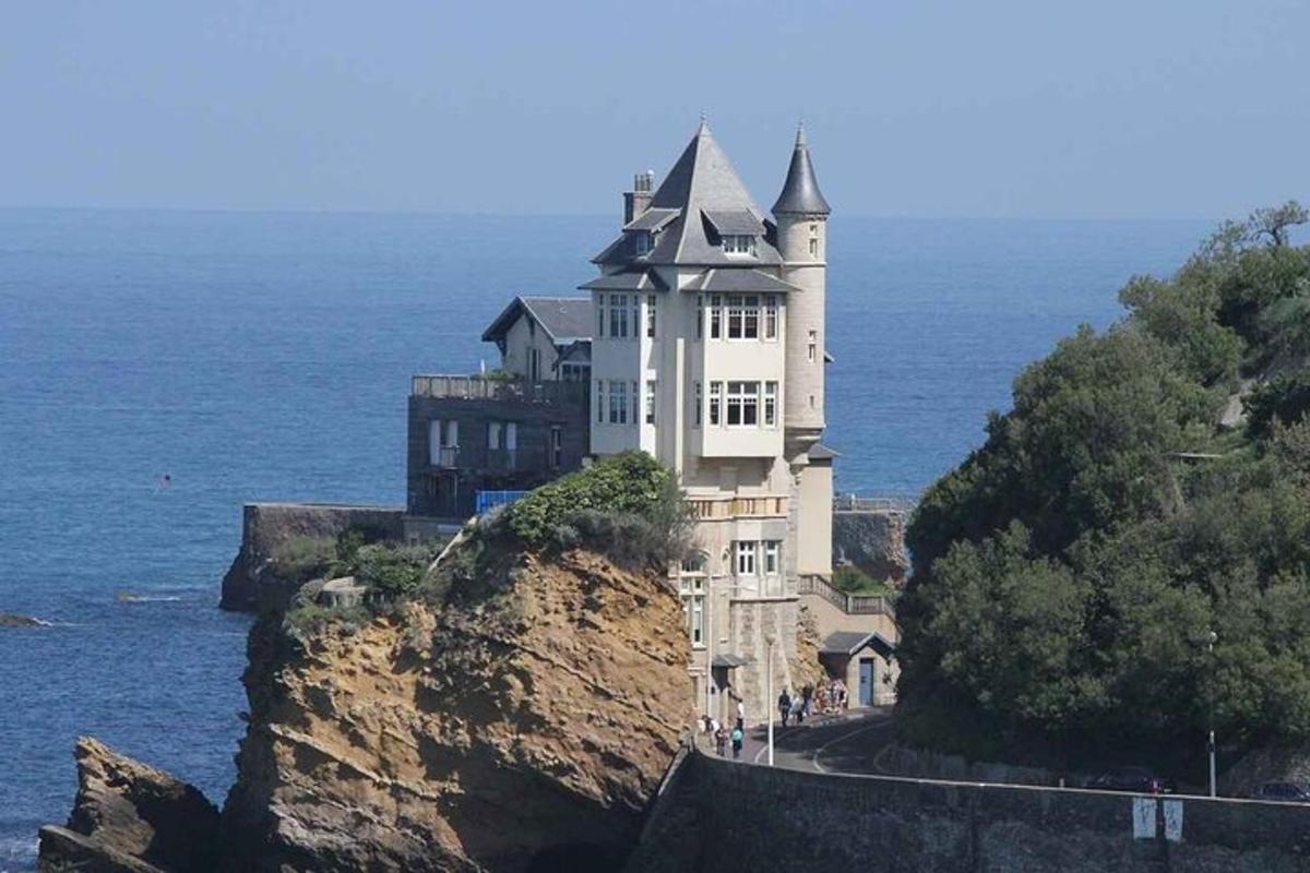 um grande edifício branco em um penhasco perto do oceano