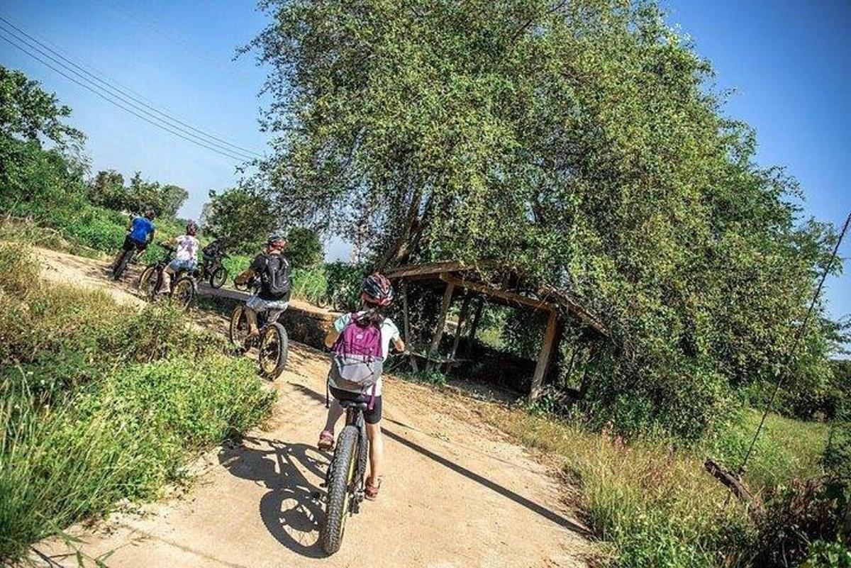 un gruppo di persone in bicicletta lungo una strada sterrata