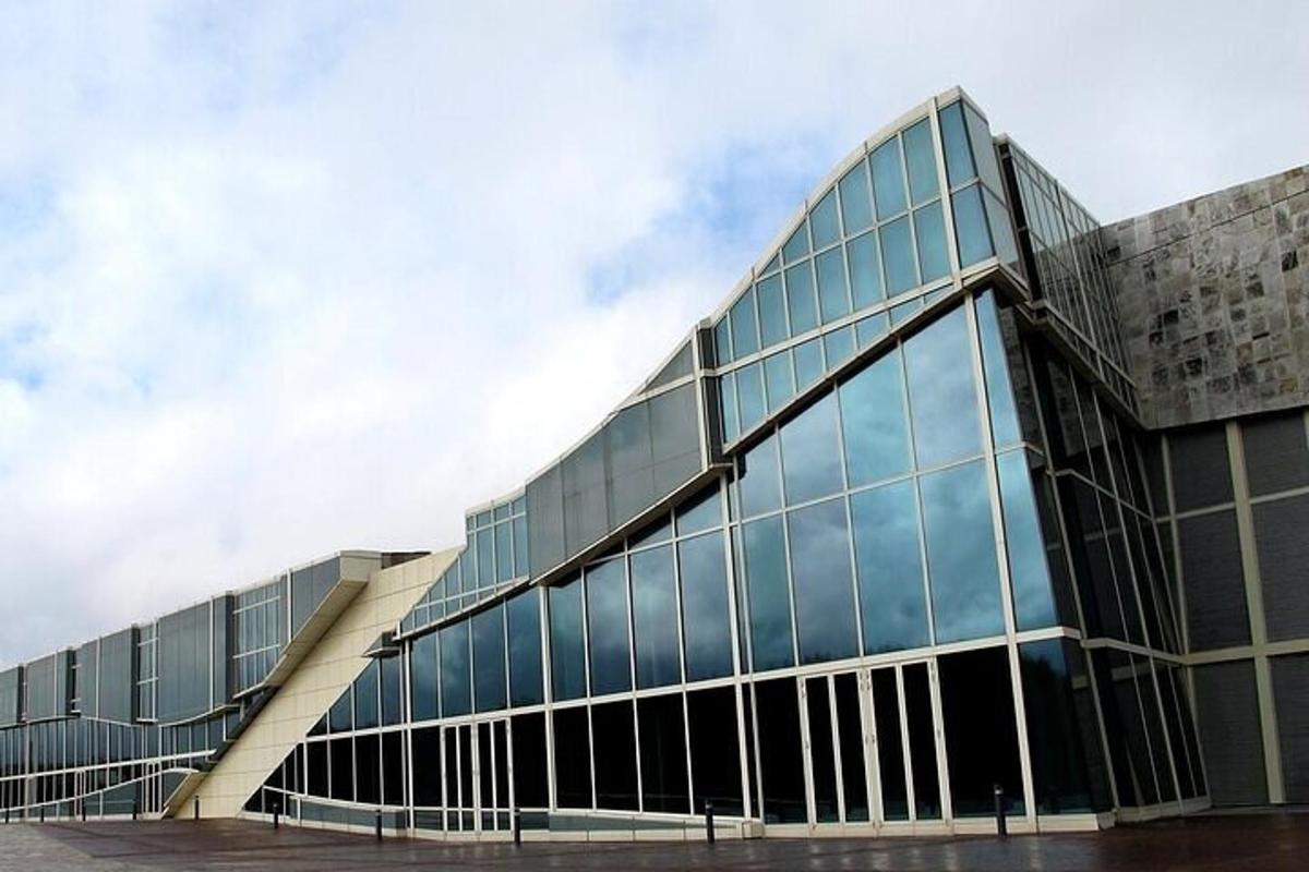 Un gran edificio de cristal con una escalera delante.