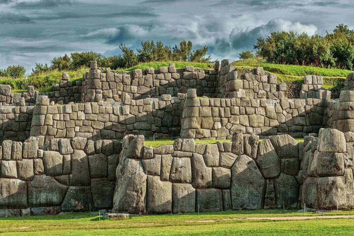 a large stone wall with a hill in the background
