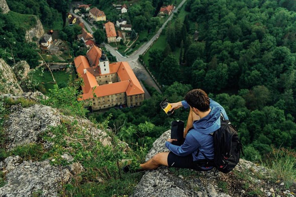 a man sitting on a rock taking a picture of a house