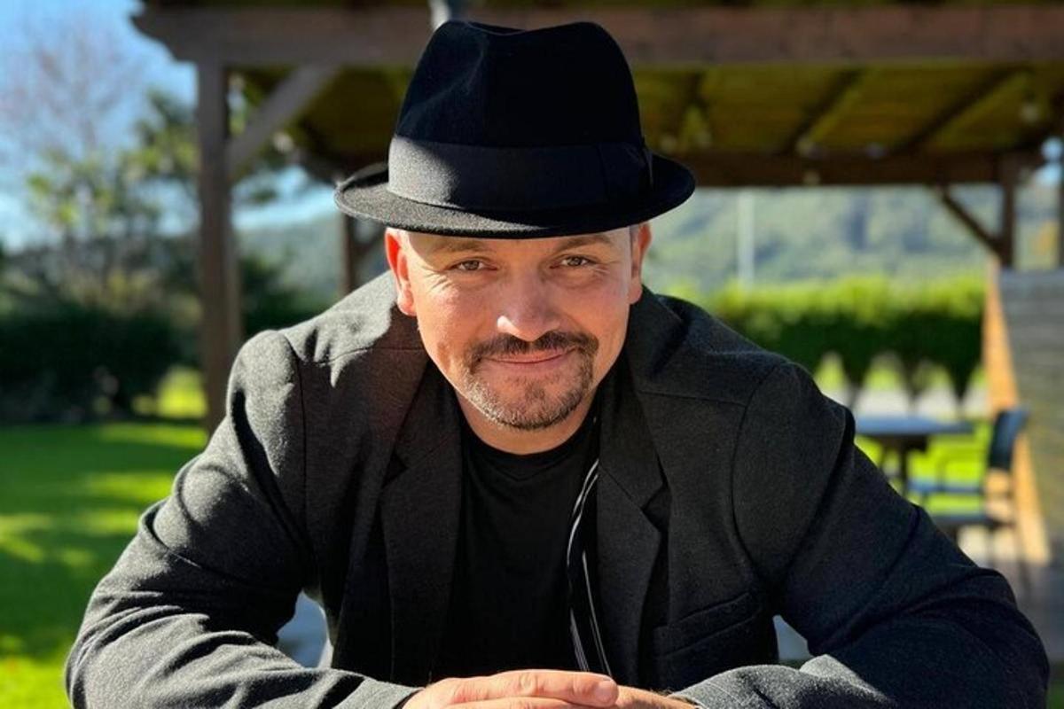 seorang lelaki memakai topi hitam duduk