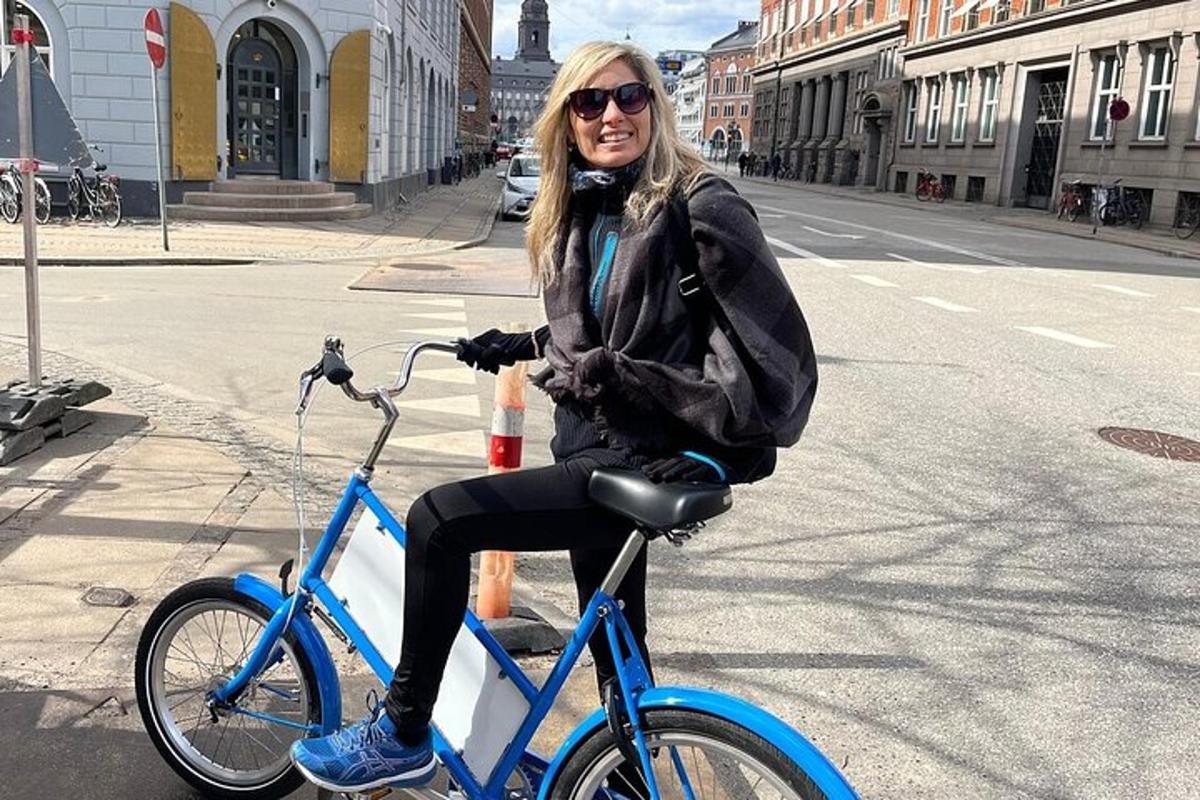 žena sedící na modrém kole na ulici