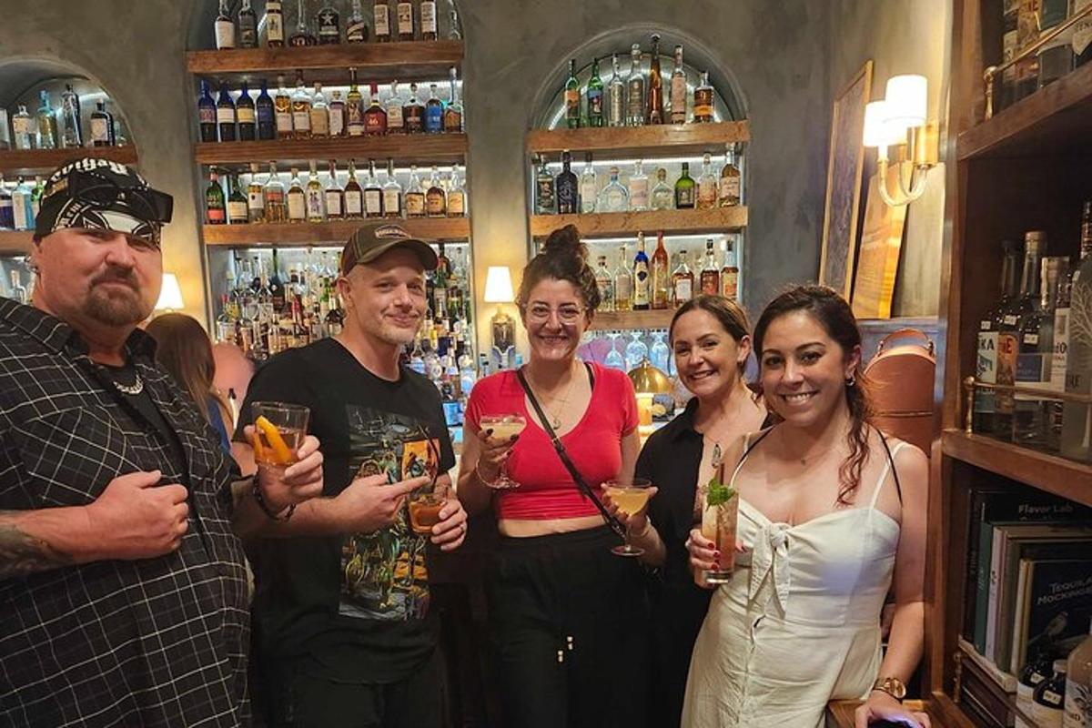 um grupo de pessoas em pé em um bar segurando bebidas