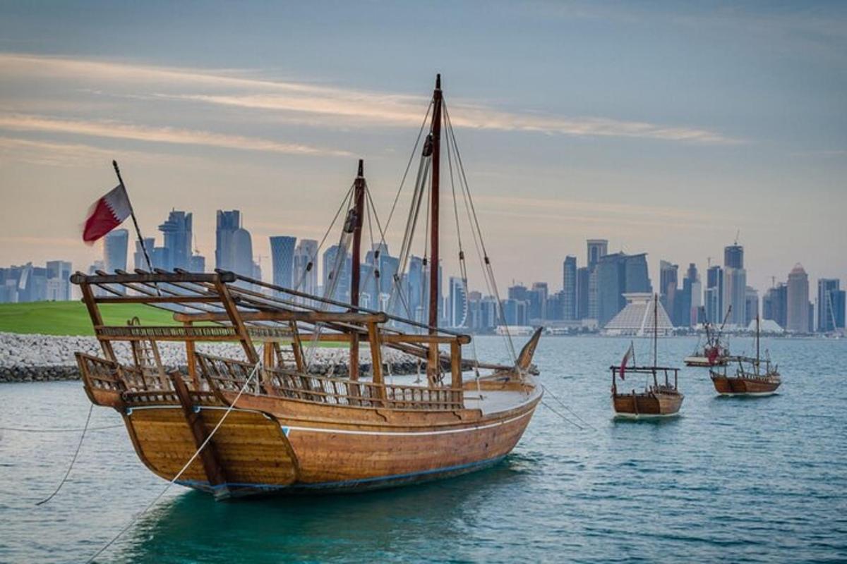 เรือสามลำในน้ำพร้อมเมืองเป็นฉากหลัง