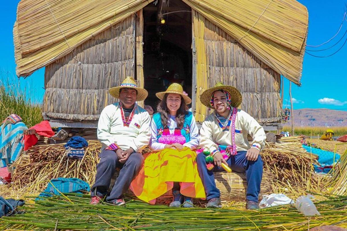 a group of three people sitting in front of a hut
