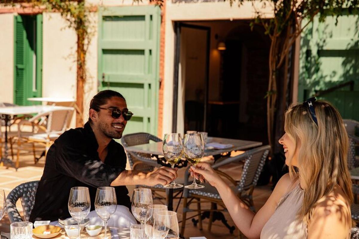 Un hombre y una mujer sentados en una mesa con copas de vino.
