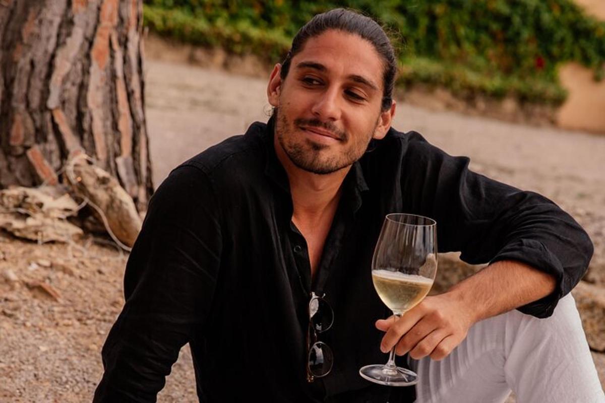 un hombre sosteniendo una copa de vino blanco