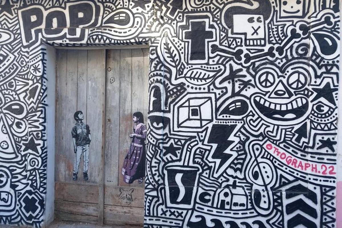 un muro coperto di graffiti con una persona in piedi su una porta