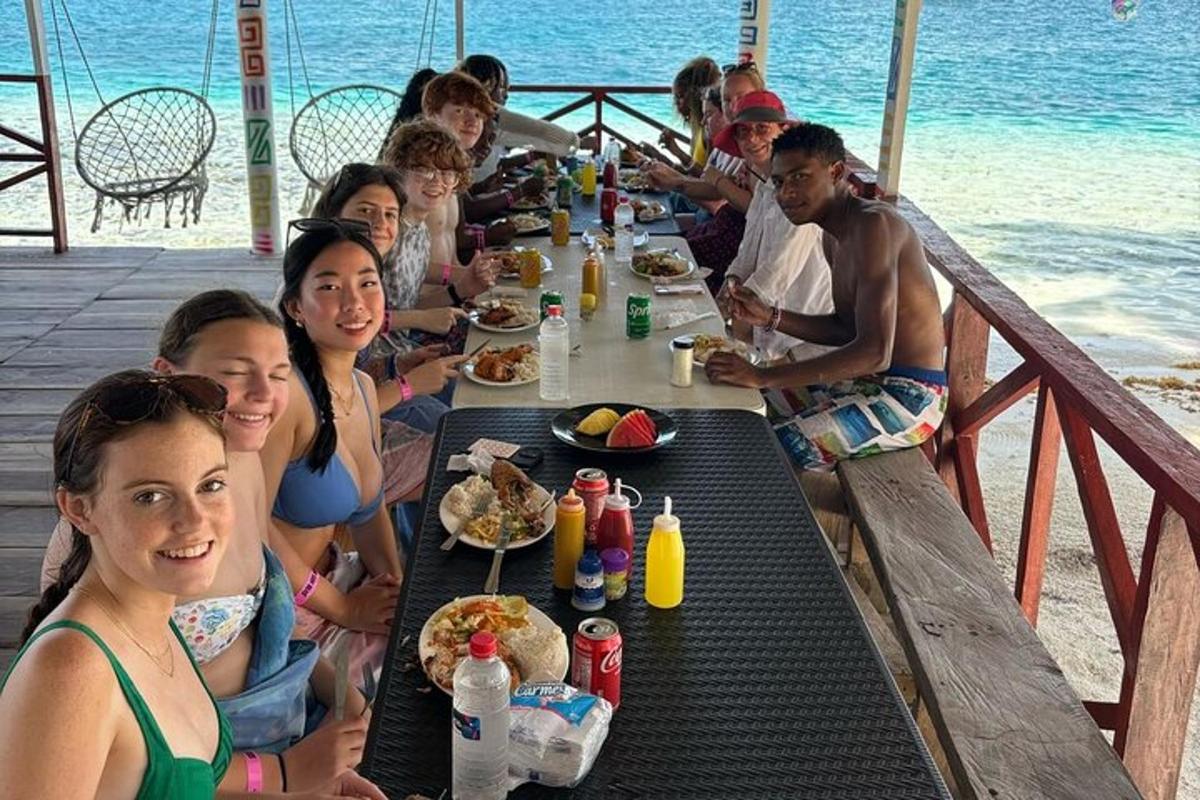 un gruppo di persone sedute a un lungo tavolo che mangiano cibo