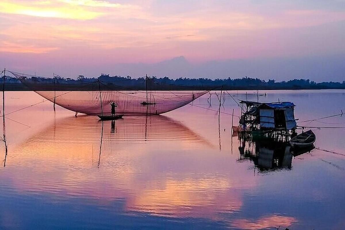 um grande barco parado na água ao pôr do sol