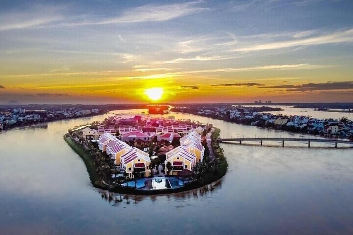 uma vista aérea de um resort em um rio ao pôr do sol