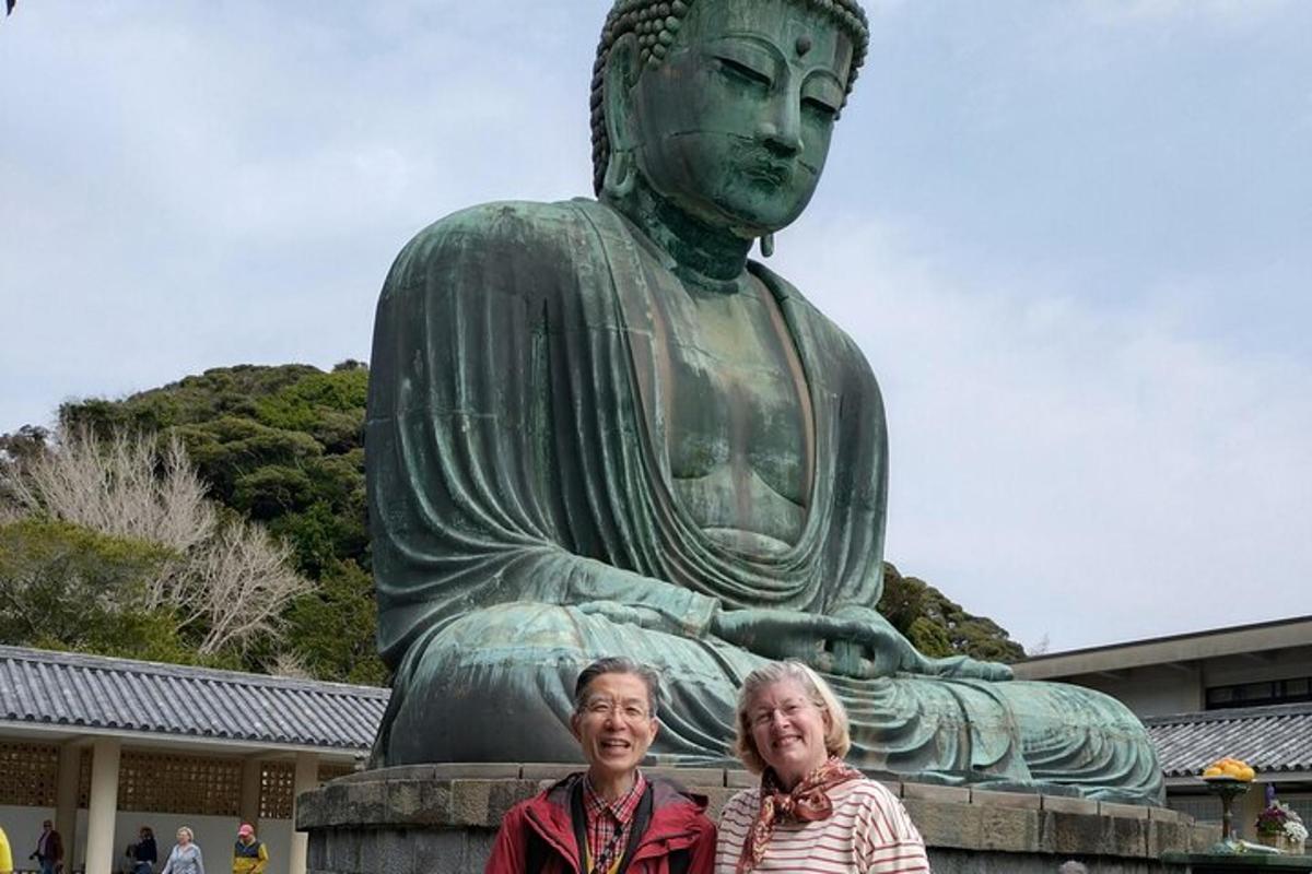 duas mulheres em pé em frente a uma estátua