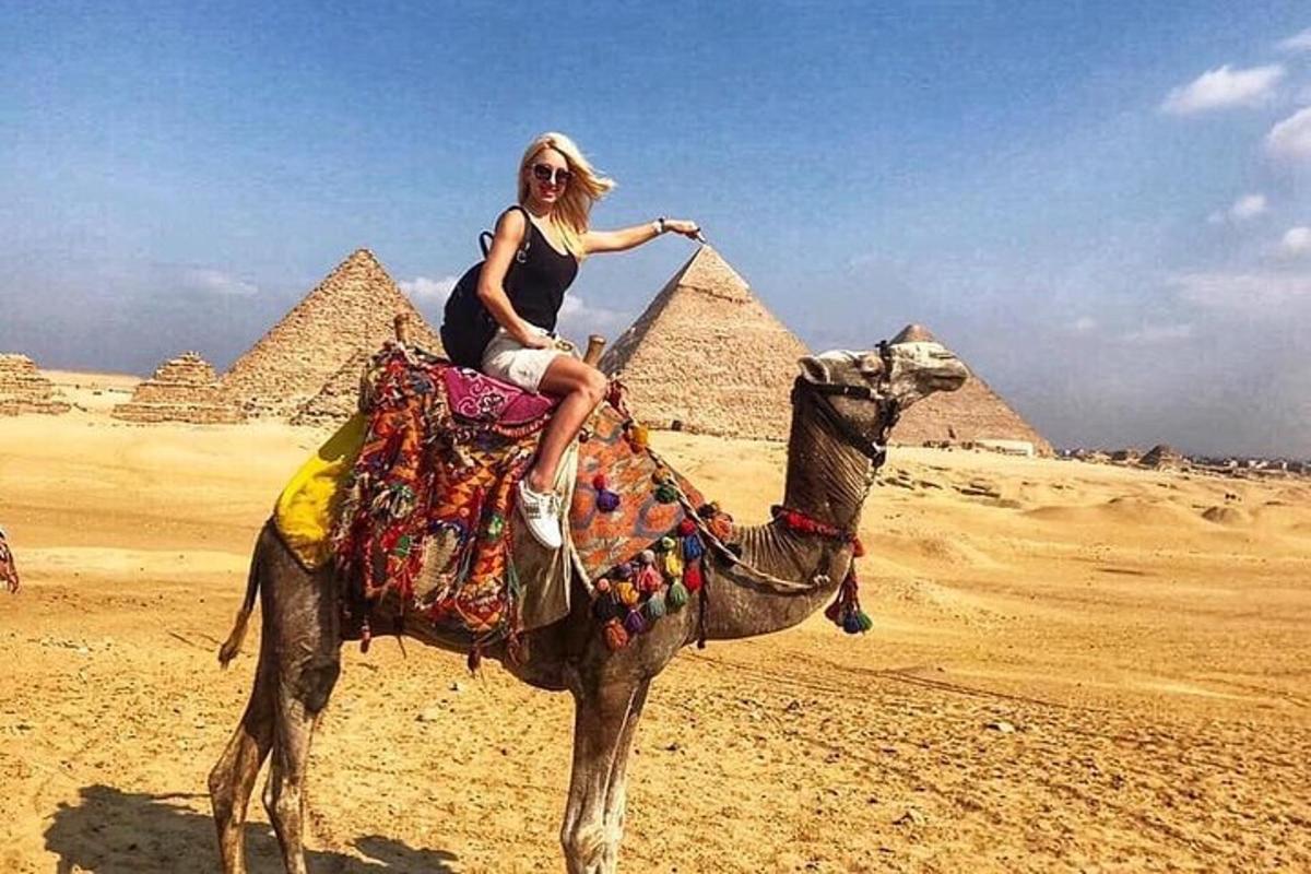 امرأة تركب الجمل أمام الأهرامات