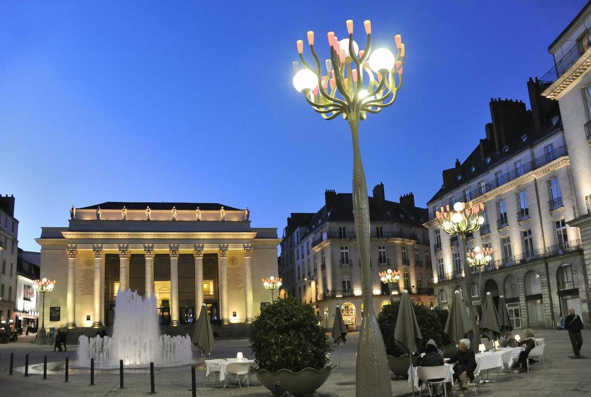 a fountain in the middle of a city with a building