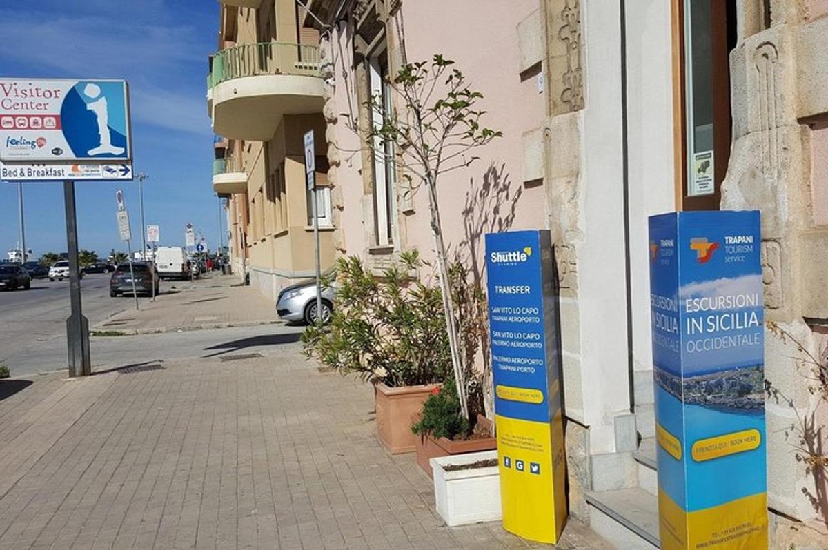 uma placa na lateral de um prédio na calçada