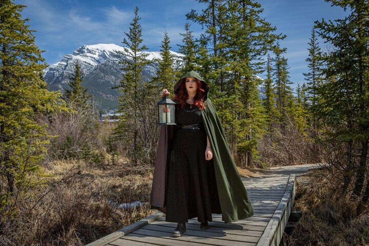 a woman is standing on a boardwalk wearing a green cape