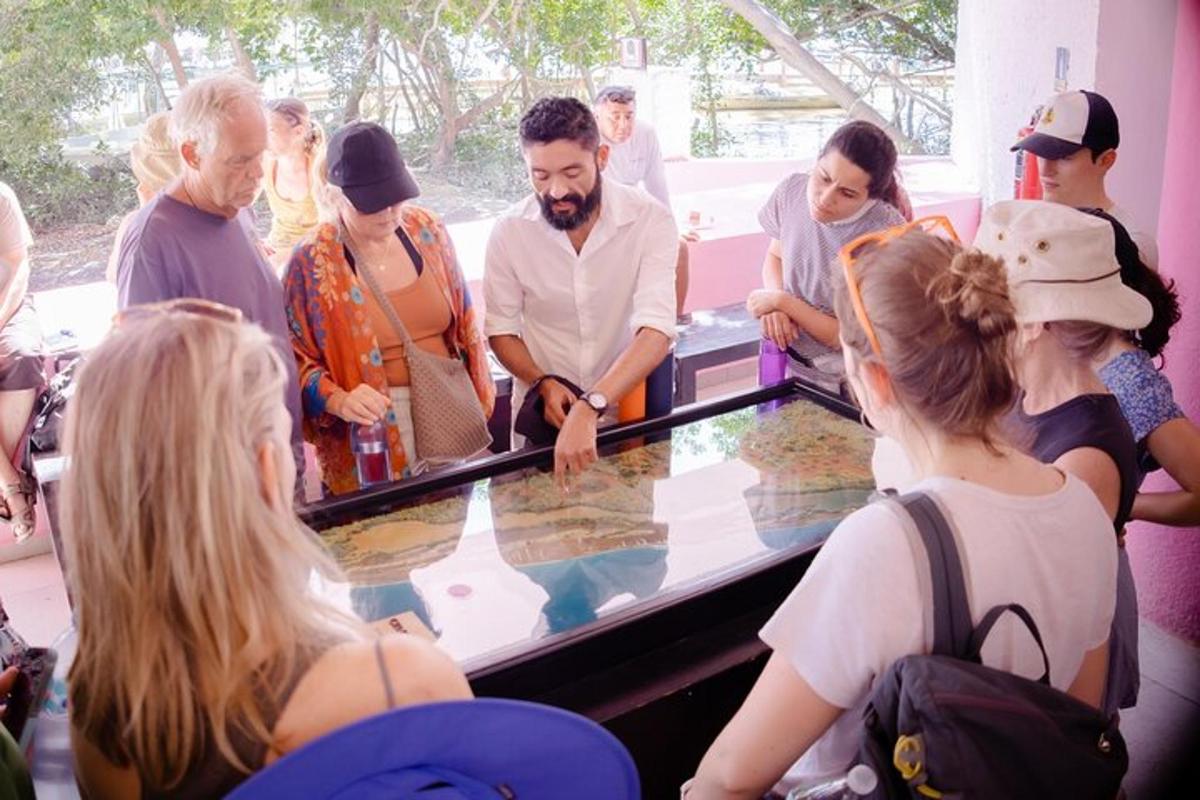 Un grupo de personas de pie alrededor de un mostrador de cristal.
