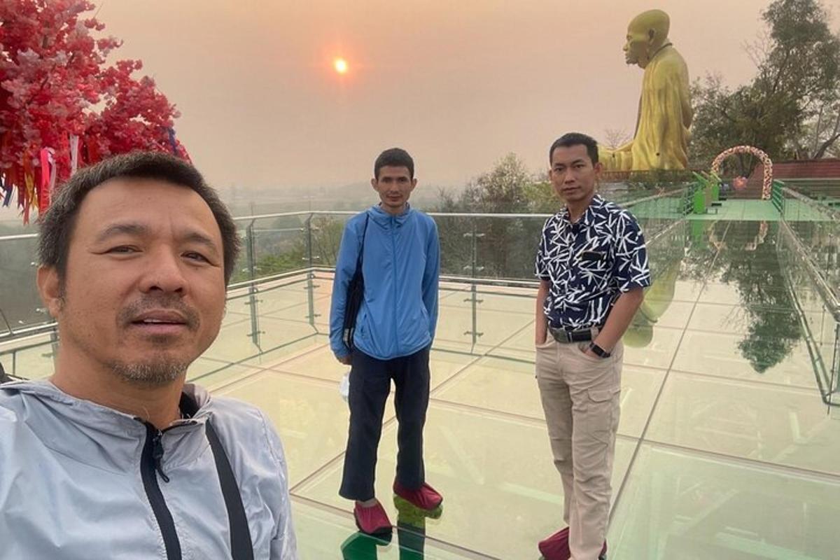 sekumpulan tiga lelaki berdiri di hadapan patung