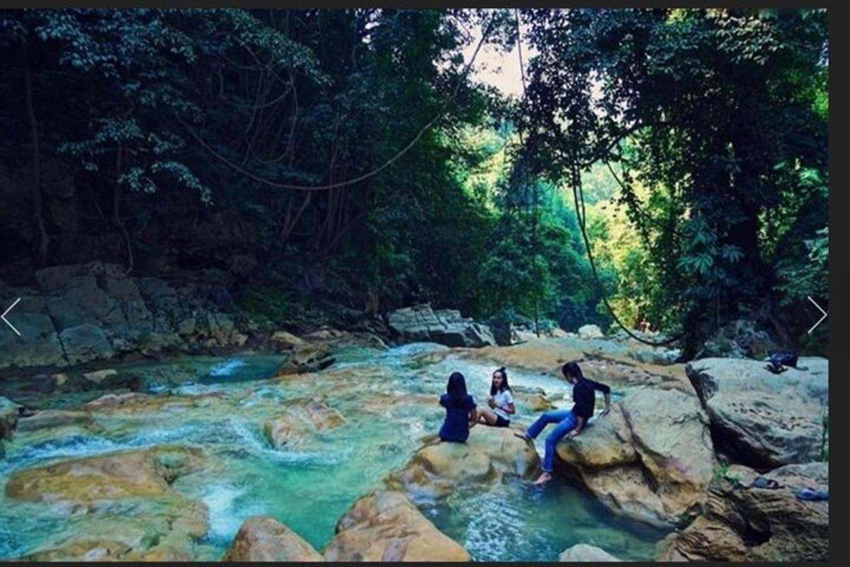 sekumpulan orang duduk di atas batu di sungai
