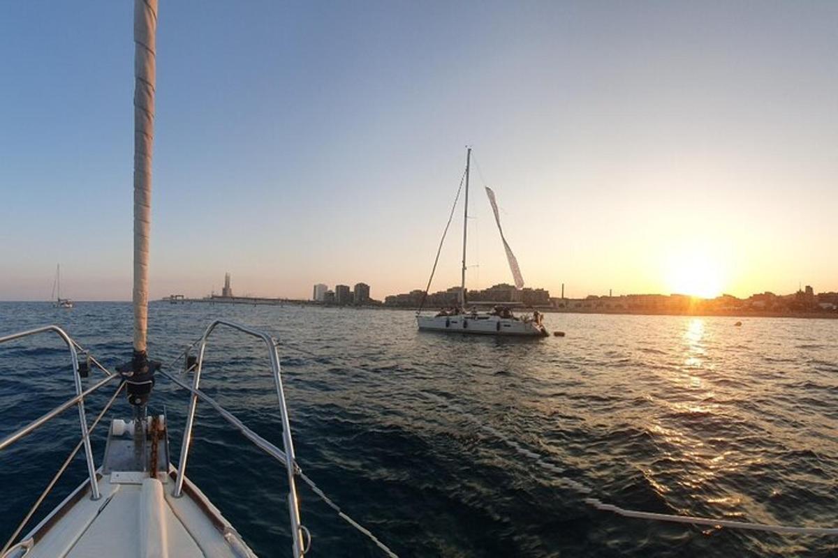 una barca a vela in acqua con il sole che tramonta