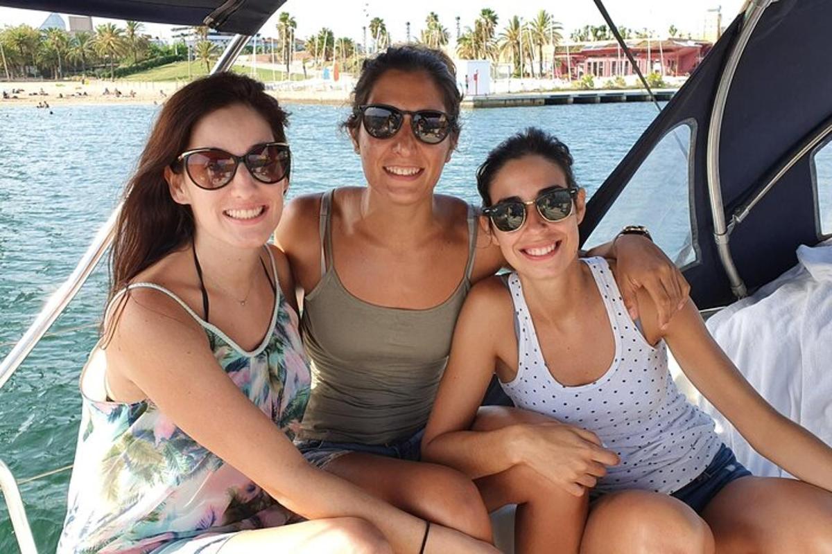three women sitting in the back of a boat