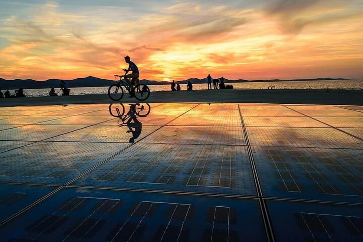 a person riding a bike on the beach at sunset