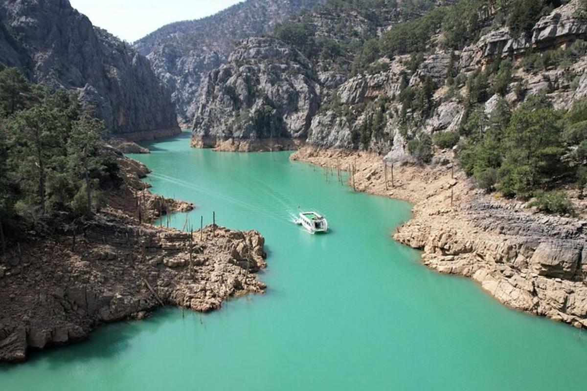 a boat in the middle of a river in a canyon