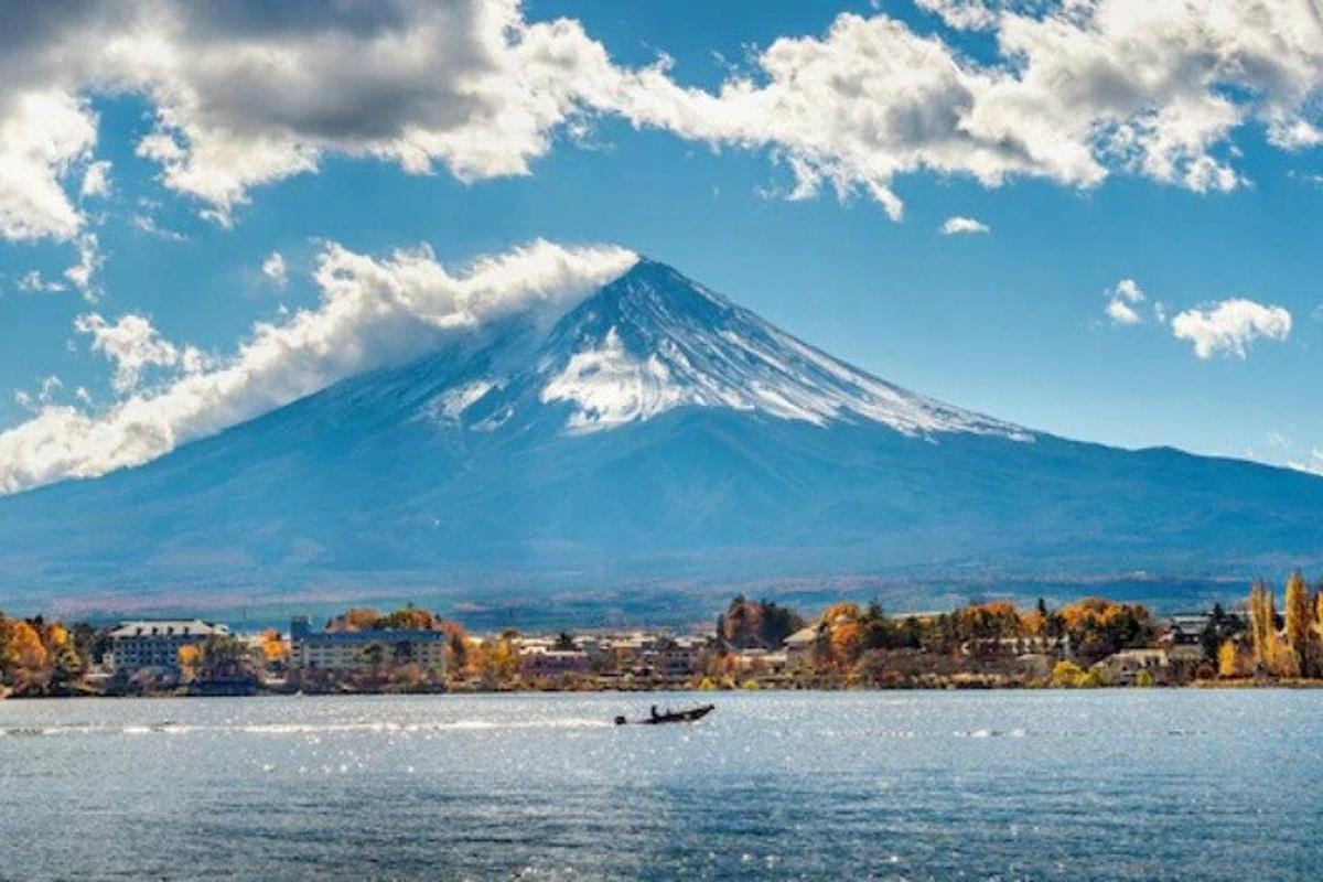 Una montaña a lo lejos con un barco en el agua.