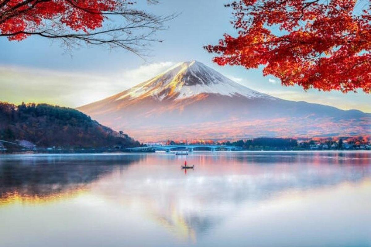 una montaña en un lago con un barco en el agua