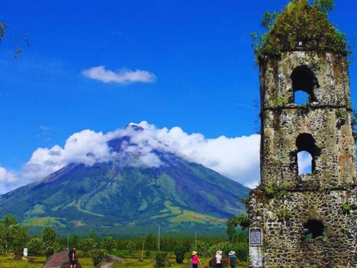 an old tower with a mountain in the background