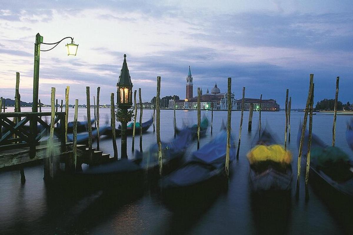 a group of boats in the water next to a street light