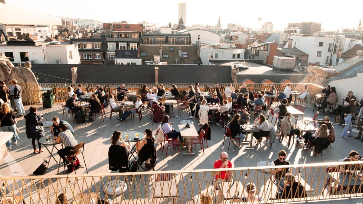 a group of people sitting at tables on a rooftop