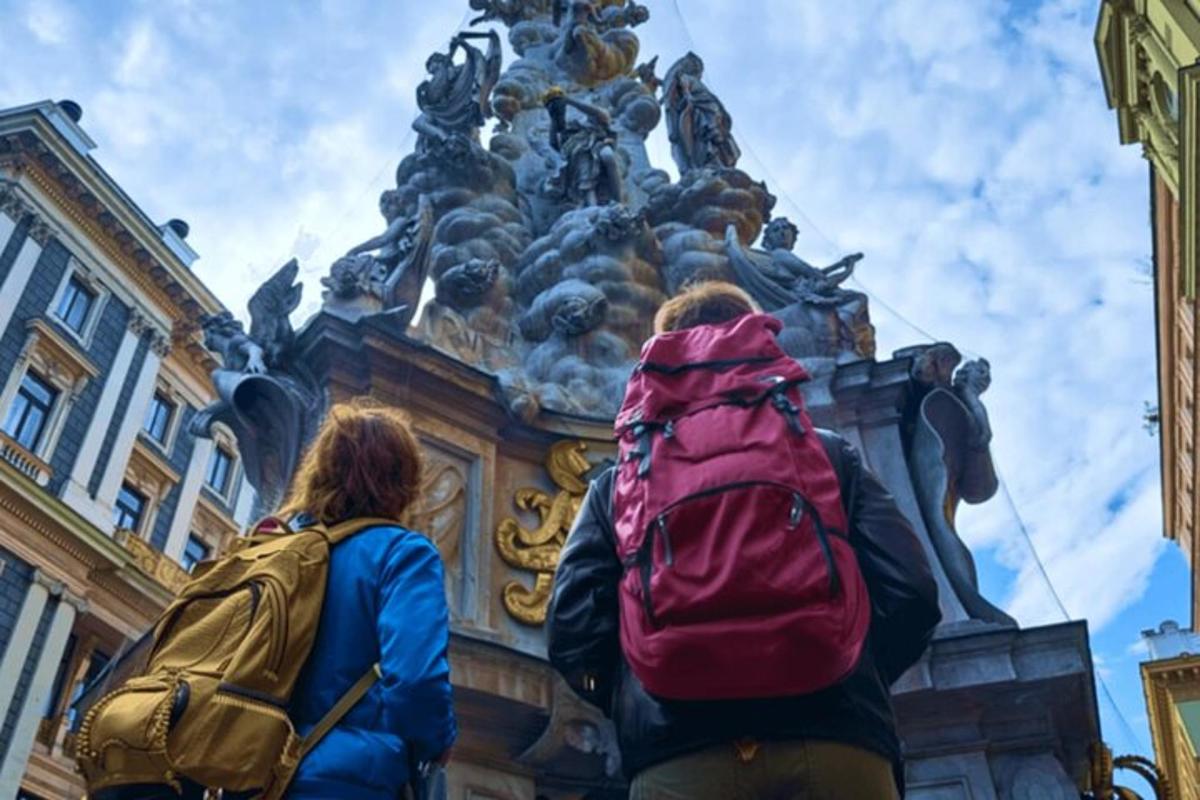 Dos personas con mochilas de pie frente a un edificio.