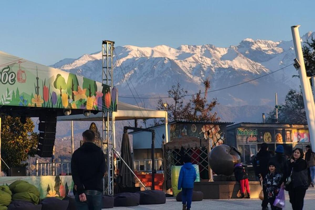 um grupo de pessoas caminhando em frente a um prédio com montanhas