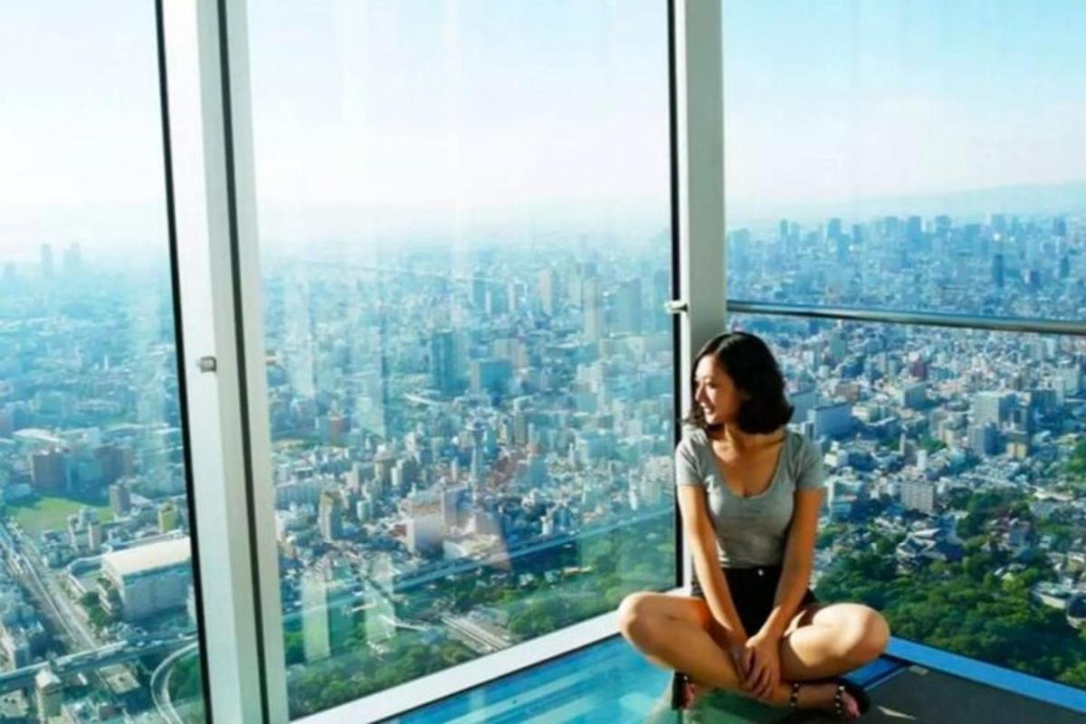 Una mujer sentada en el borde de una plataforma de observación en el Shanghaiosphere.