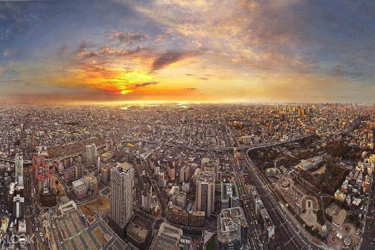 Una pintura de una gran ciudad con una puesta de sol.