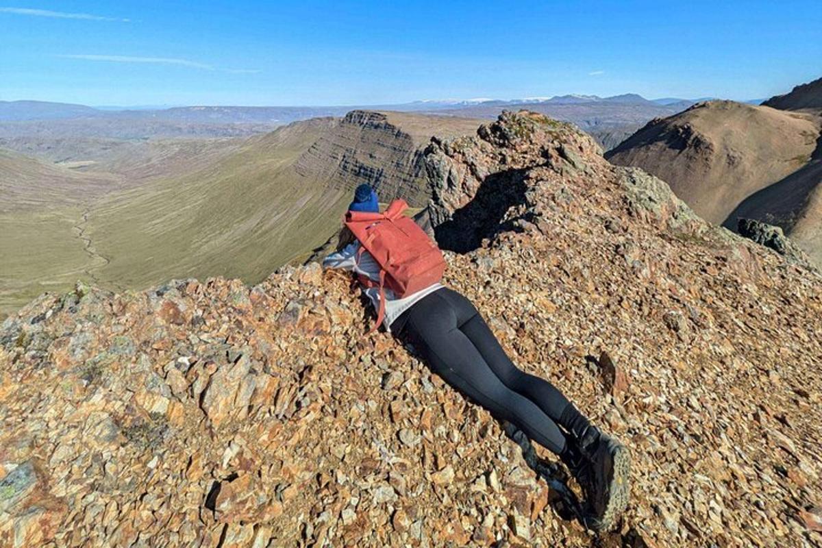 maður sem liggur á fjallstindi