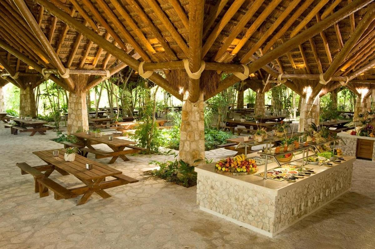 een groot houten paviljoen met tafels en picknicktafels