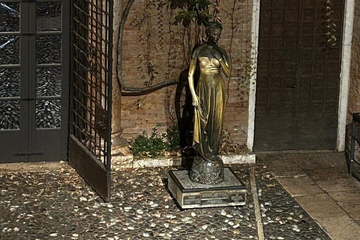 en statue av en kvinne som står ved siden av en bygning