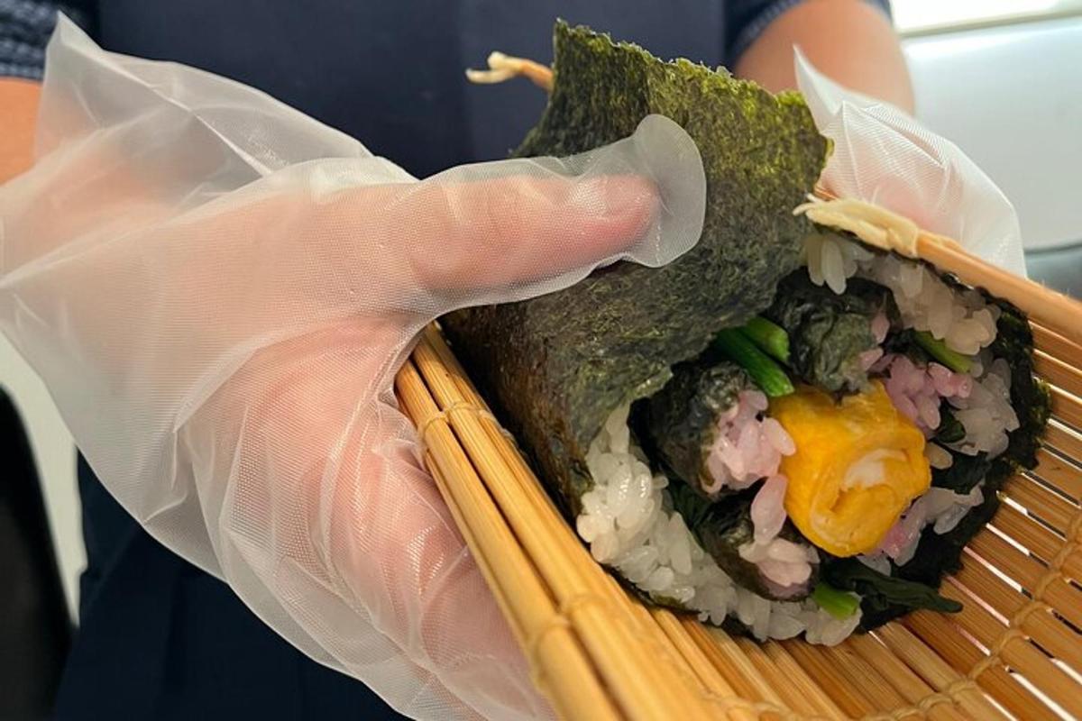 osoba držící košík sushi s košíkem jídla